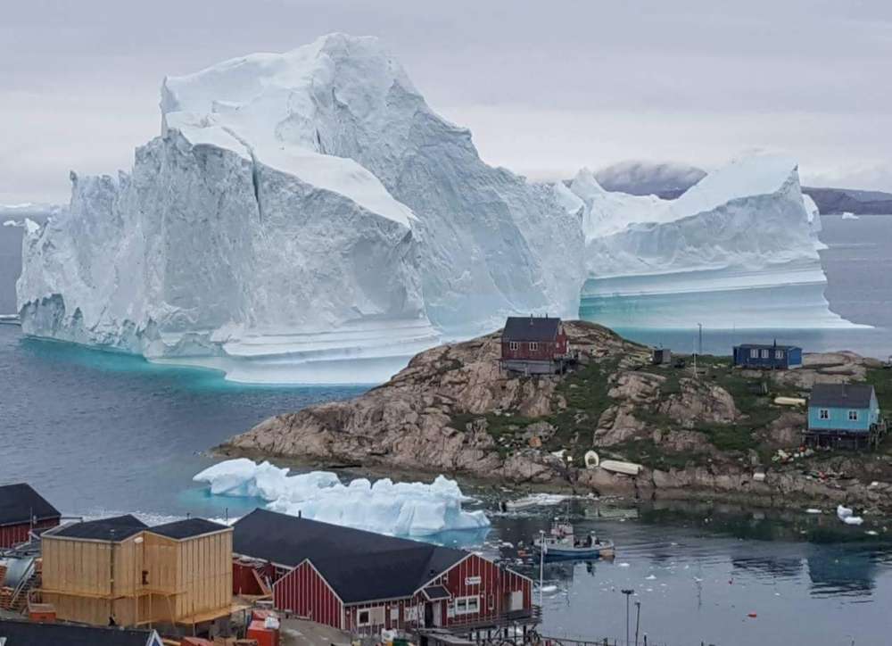 Huge iceberg drifts close to Greenland village