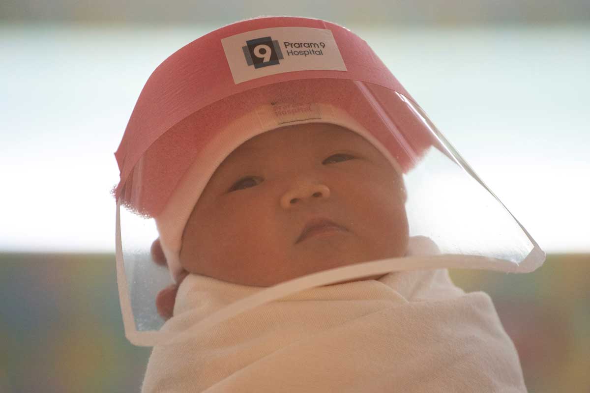 Newborn with protective face shield