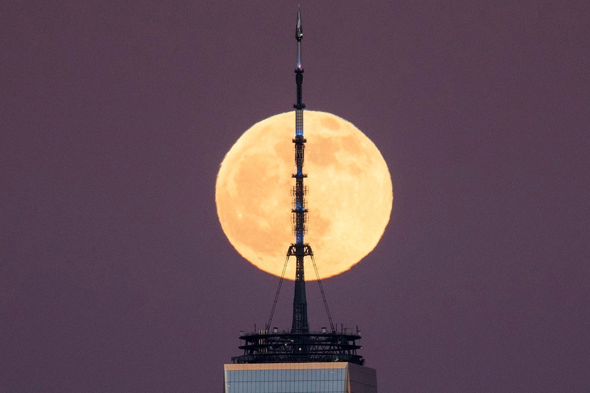 Μια πανσέληνος γνωστή ως η κρύα Σελήνη υψώνεται πίσω από το Κέντρο Παγκόσμιου Εμπορίου