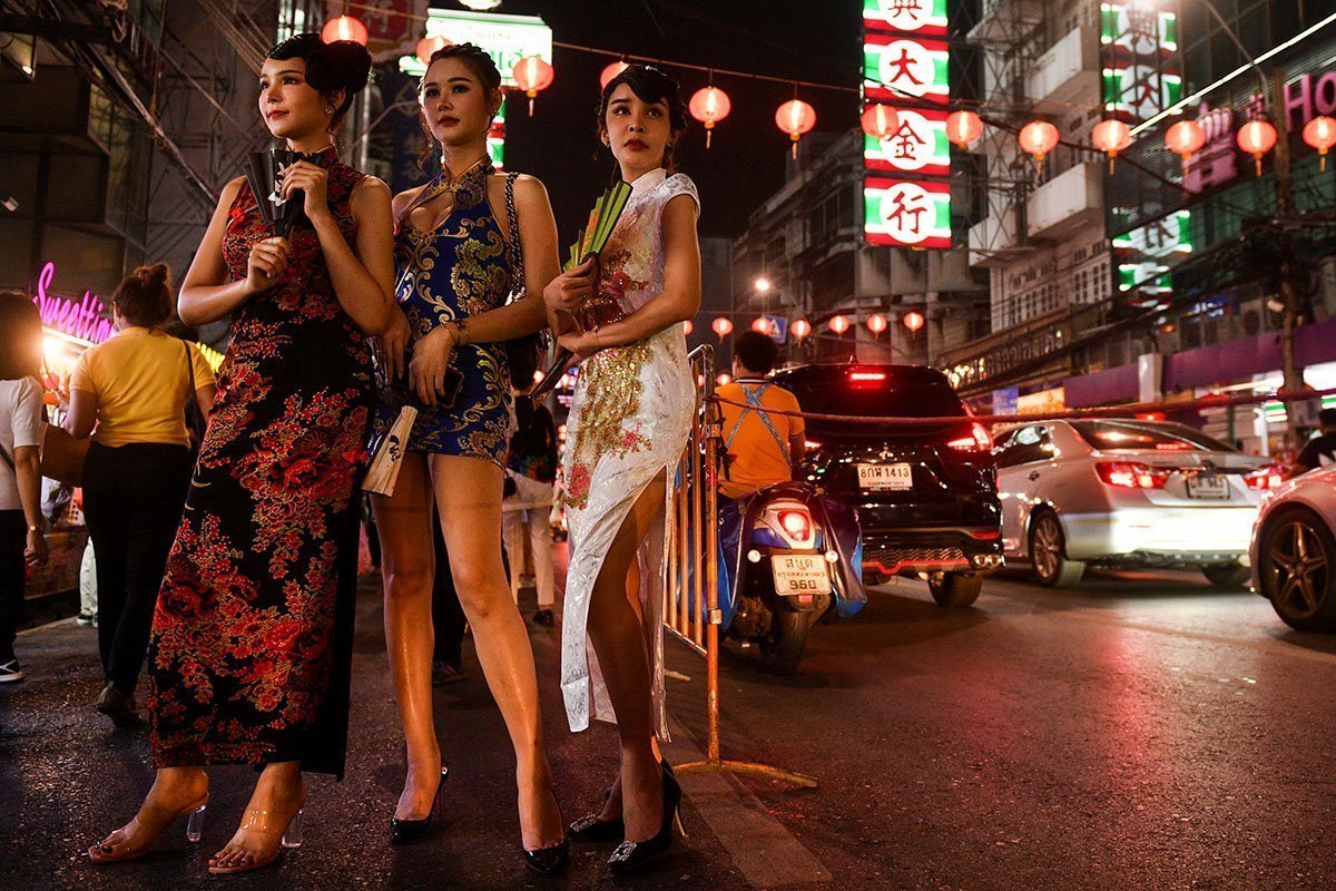 Οι γυναίκες στέκονται σε έναν δρόμο μπροστά από τον εορτασμό της σεληνιακής Πρωτοχρονιάς