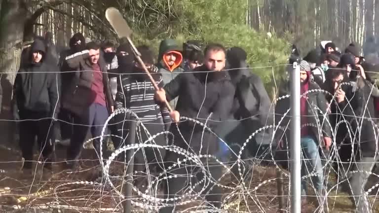 Migrant Uses Shovel To Break Through Fence On Poland Belarus Border