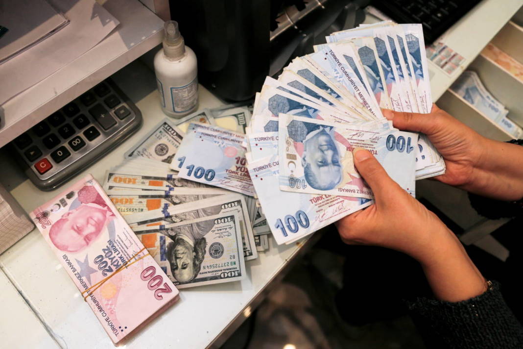 File Photo: A Money Changer Holds Turkish Lira Banknotes At A Currency Exchange Office In Ankara