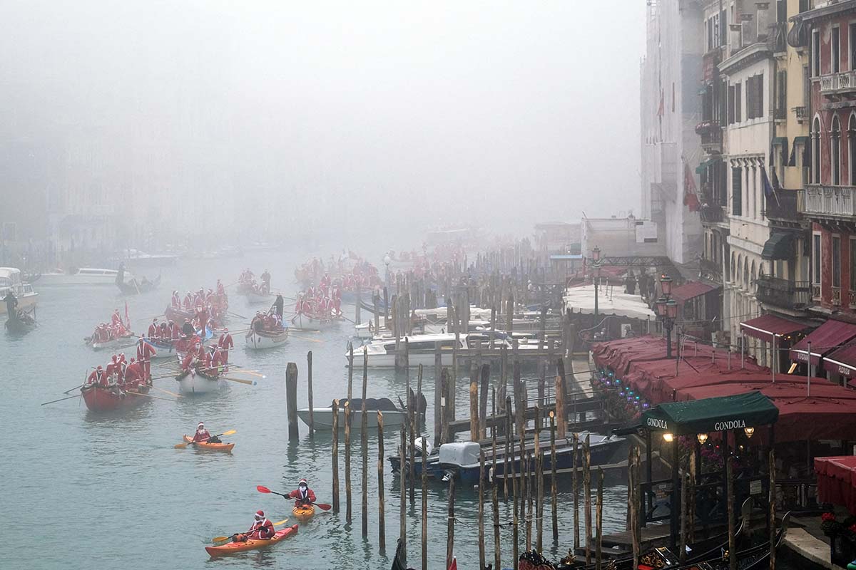 People Dressed As Santa Claus Row During A Christmas Regatta In Venice