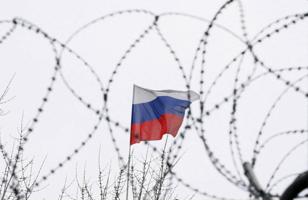 File Photo: The Russian Flag Is Seen Through Barbed Wire As It Flies On The Roof Of The Russian Embassy In Kiev