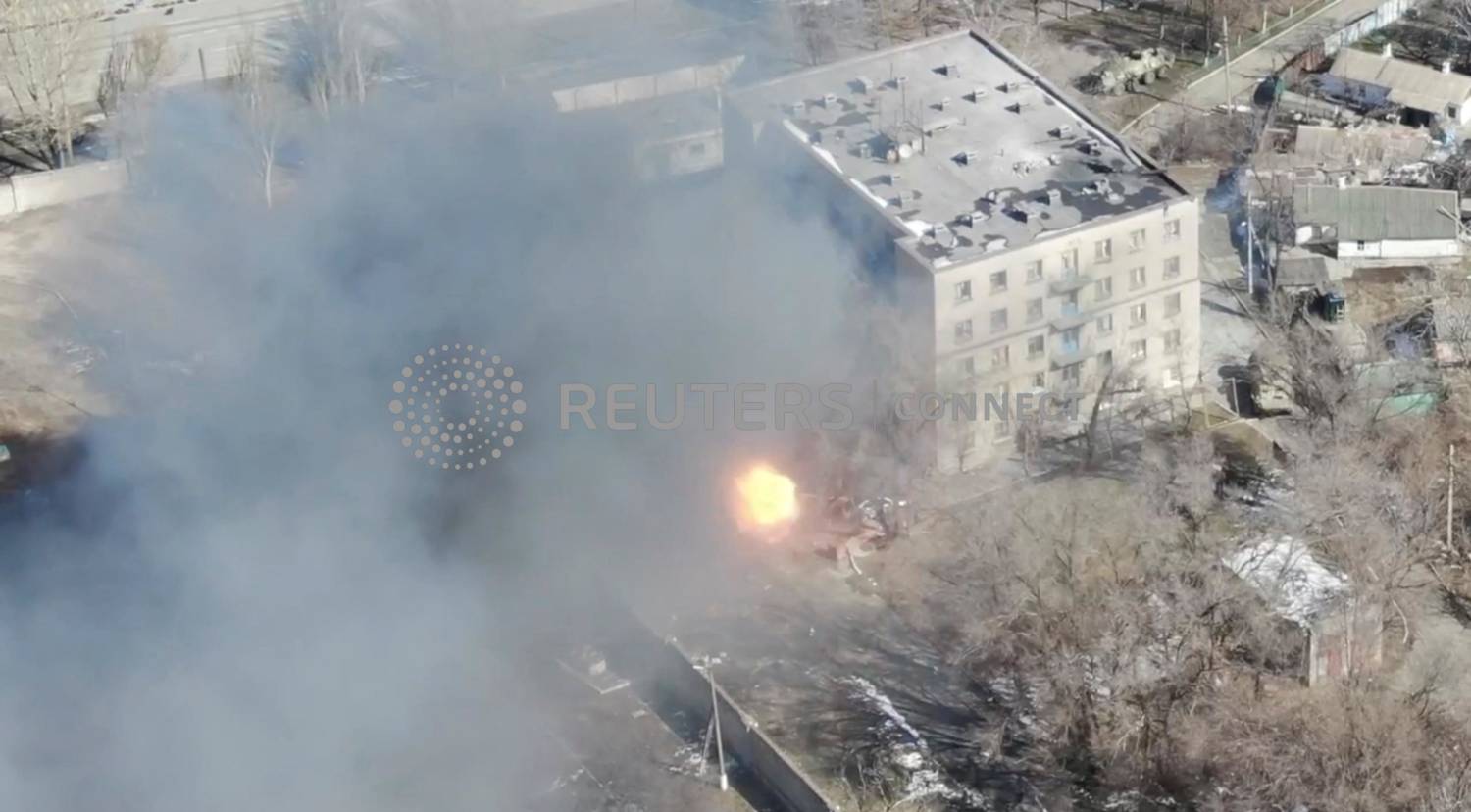 An Aeriel View Shows A Military Vehicle Shoot Rounds Next To A Building, As Russia's Invasion Of Ukraine Continues, In Maripuol