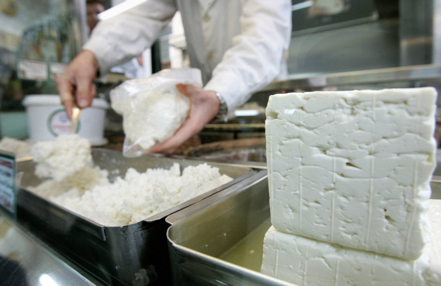 File Photo: A Cheesemonger Puts Pieces Of Greece's Trademark Feta Cheese In A Bag For A Customer In Central Athens,