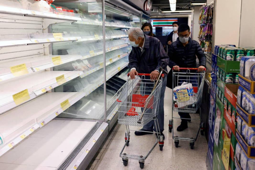 Customers Wearing Masks Shop In Front Of Partially Empty Shelves At A Supermarket In Hong Kong