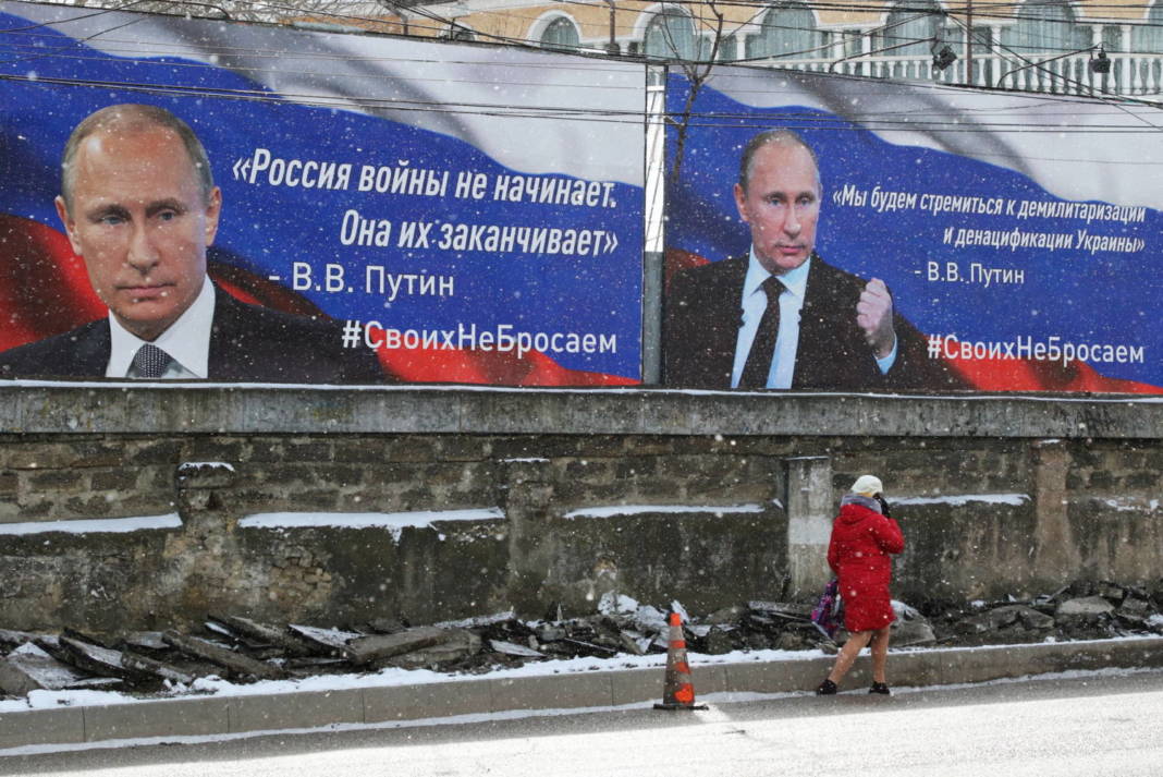 A Woman Walks Past Boards With Portraits Of Russian President Vladimir Putin In Simferopol