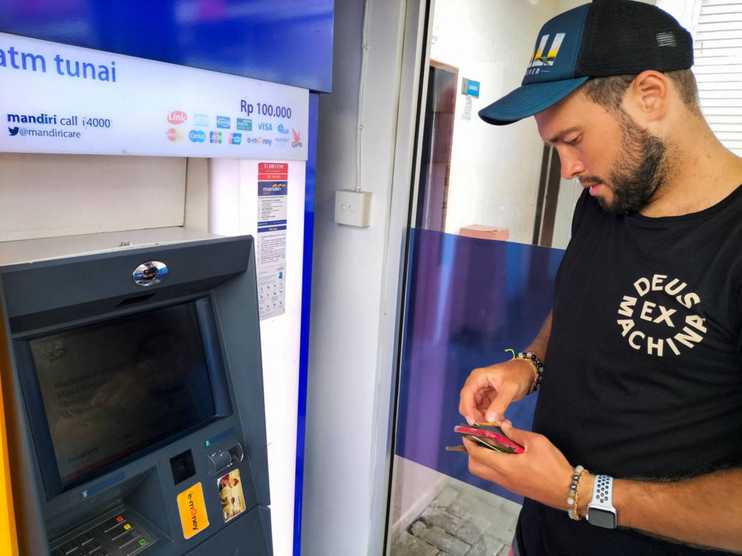 Konstantin Ivanov, A 27 Year Old Russian Who Is In Bali, Holds His Cards As He Tries To Withdraw Money From His Russian Bank Account At A Cash Machine In Kuta, Bali