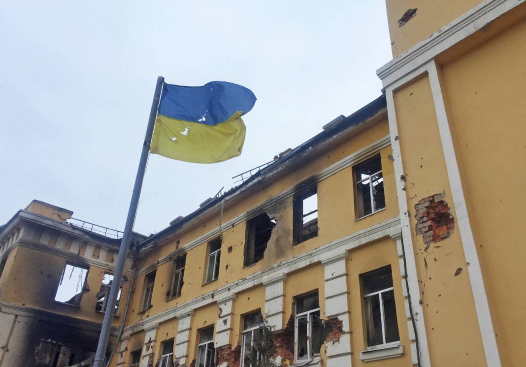 The Ukrainian National Flag Is Seen In Front Of A School Which, According To Local Residents, Was On Fire After Shelling In Kharkiv