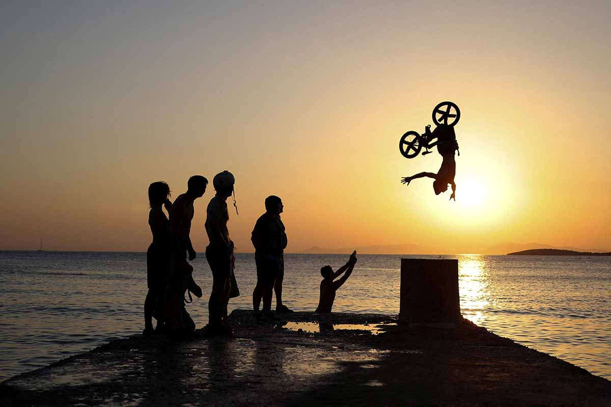 A Biker Performs Tricks At Kavouri Beach During A Heatwave Near Athens