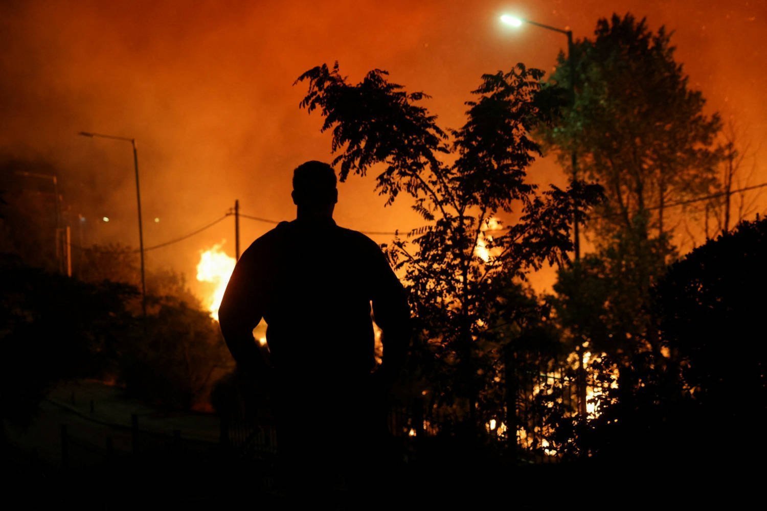 A Man Is Silhouetted As A Wildfire Burns In Ntrafi, Near Athens