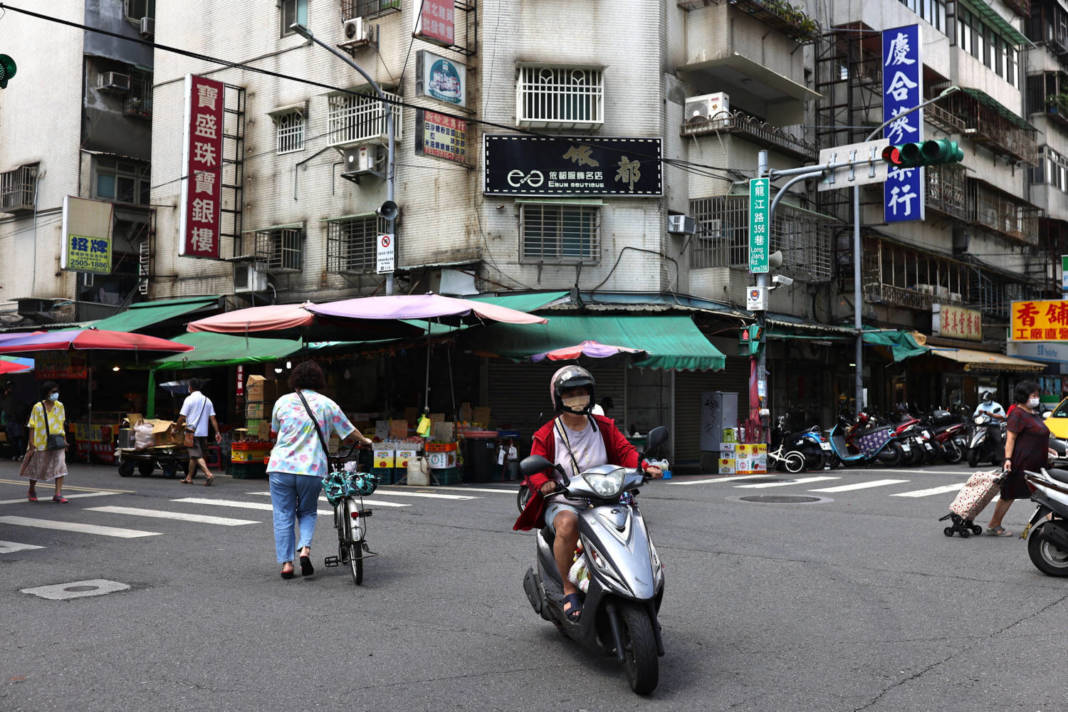 People And Traffic Pass Near A Marketplace In Taipei