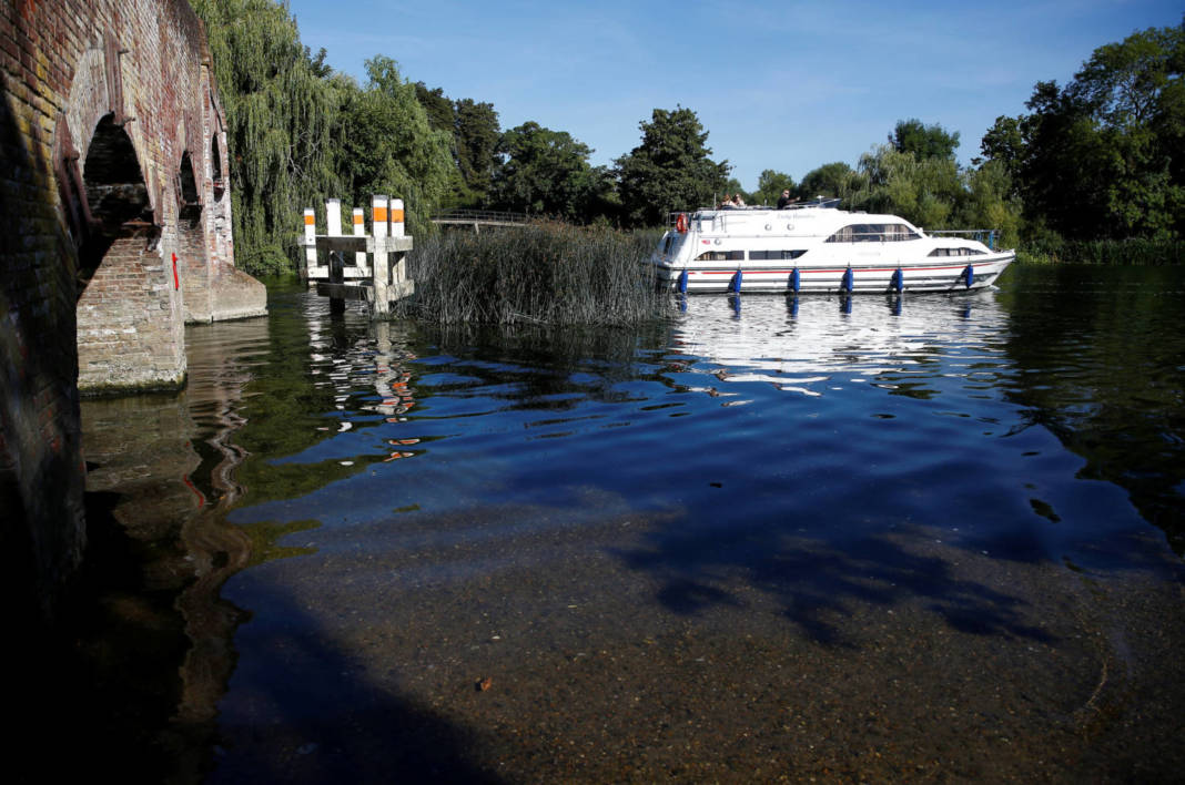 A Boat Passes Under A Bridge Where Water Levels Are Low On The River Thames In Sonning