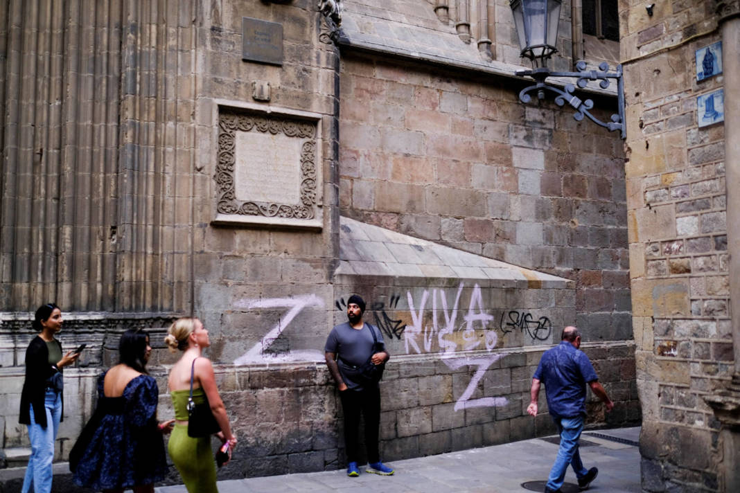 Tourists Walk Past The Cathedral Wall In Barcelona, Painted With The Letter 'z', The Symbol Of The Russian Military, Following Russia's Invasion Of Ukraine