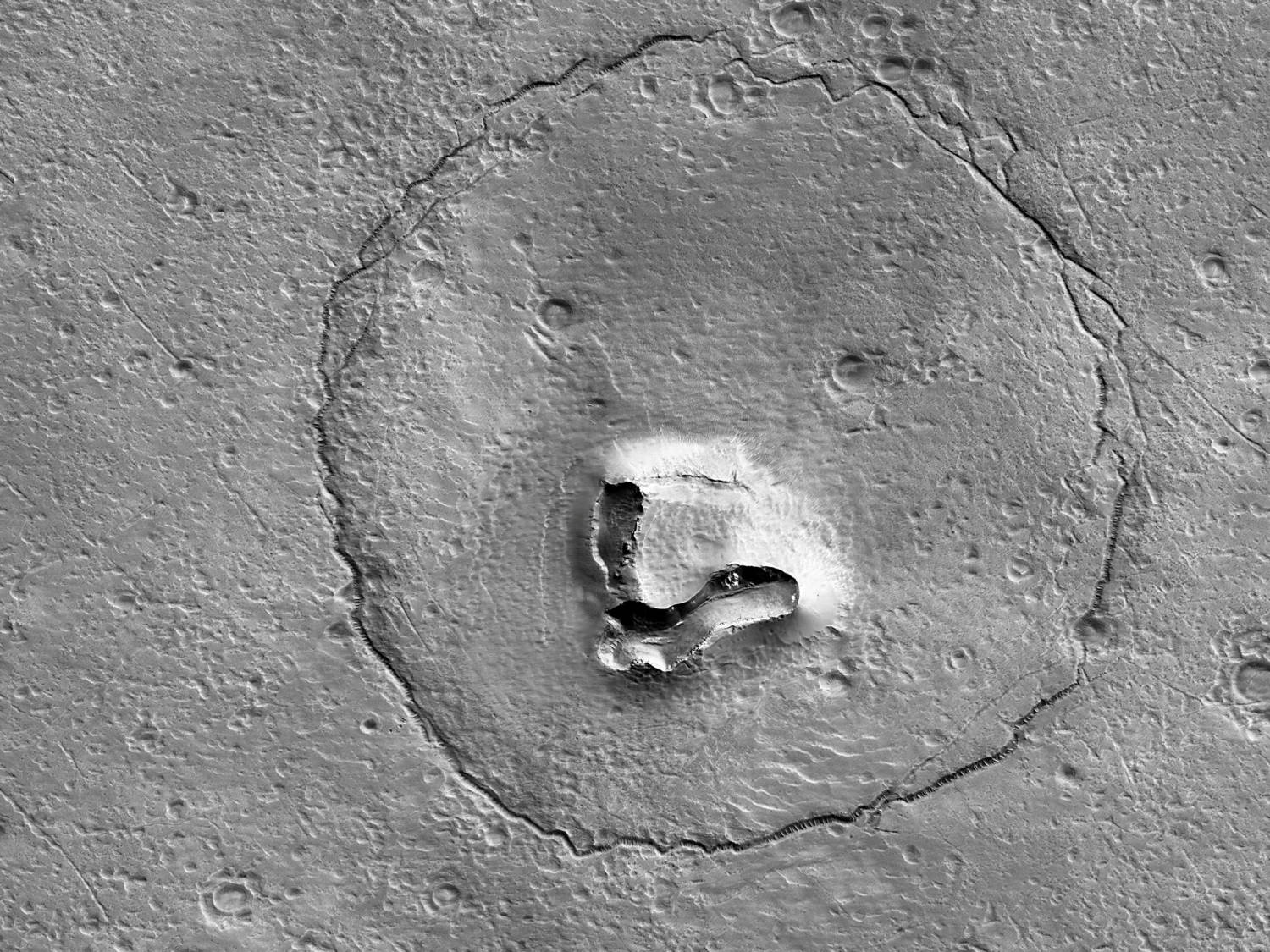 An Undated Image From Nasa's Mars Reconnaissance Orbiter Shows Hills, Craters And A Circular Fracture Pattern On The Surface Of Mars