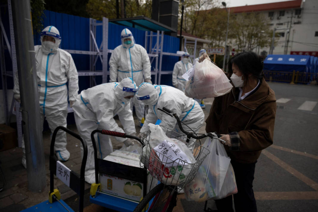 A Woman Delivers Food To A Residential Compound That Is Under Lockdown As Outbreaks Of Coronavirus Disease (covid 19) Continue In Beijing