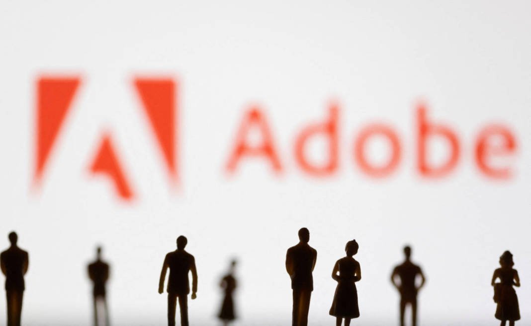 File Photo: Illustration Shows Figurines In Front Of Adobe Logo