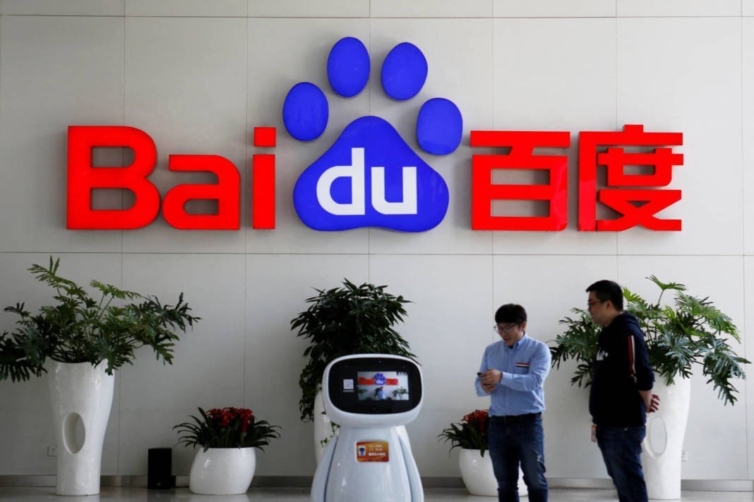 File Photo: Men Interact With A Baidu Ai Robot Near The Company Logo At Its Headquarters In Beijing