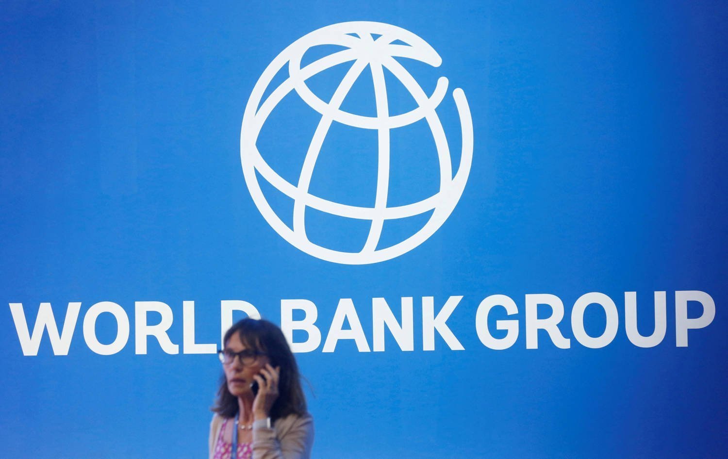 File Photo: A Participant Stands Near A Logo Of World Bank At The International Monetary Fund World Bank Annual Meeting 2018 In Nusa Dua