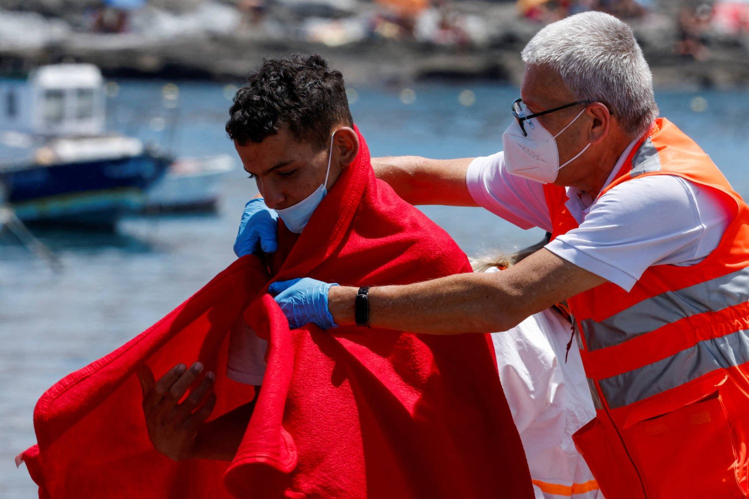 File Photo: A Member Of The Red Cross Assists A Migrant After Disembarking From A Spanish Coast Guard Vessel, At The Port Of Arguineguin