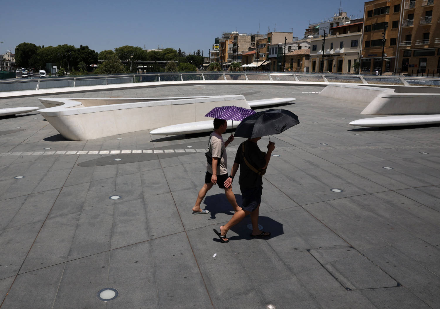 Men Shelter From The Sun With An Umbrella During A Heatwave In Nicosia