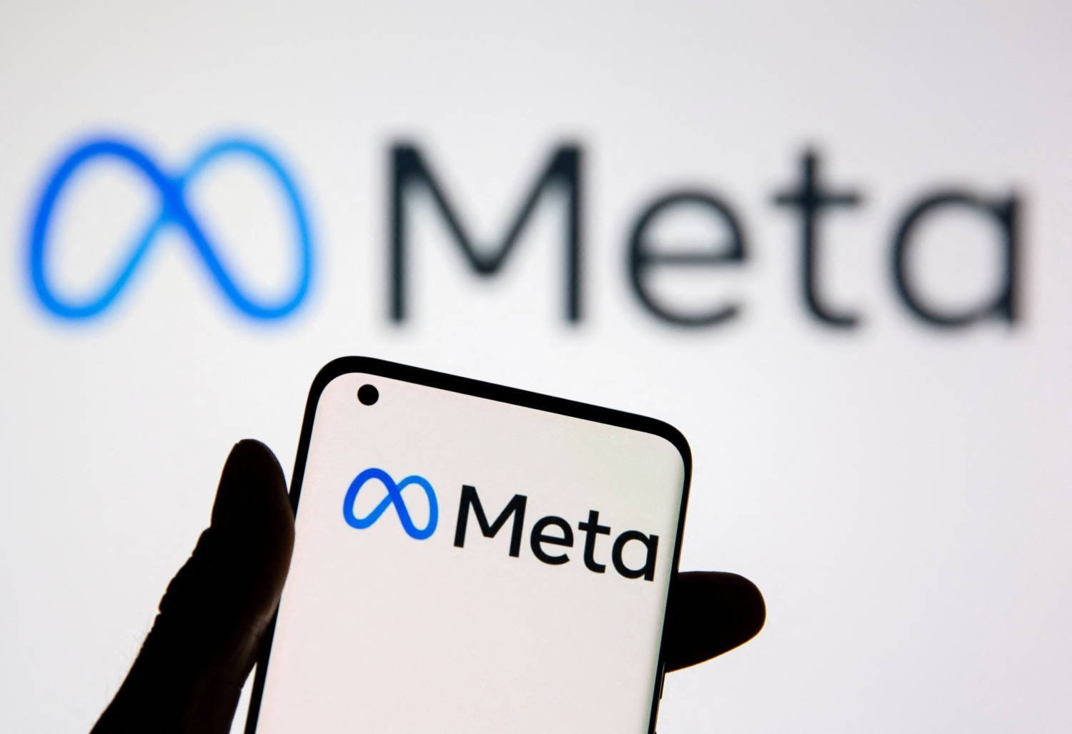 File Photo: A Smartphone With Meta Logo Is Seen In Front Of Displayed Facebook's New Rebrand Logo Meta In This Illustration
