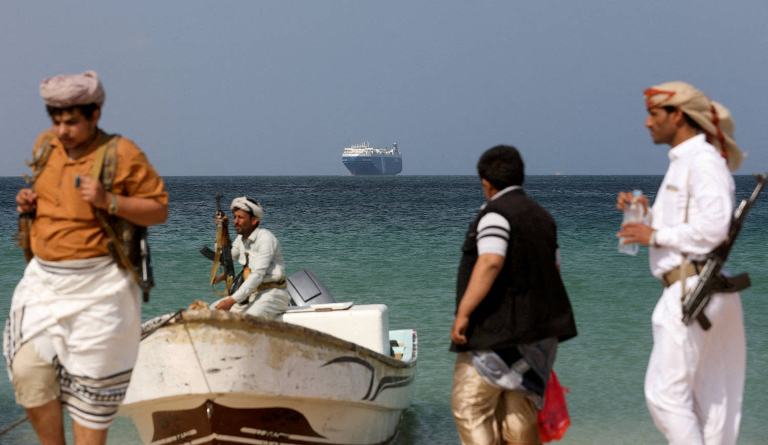 File Photo: Armed Men Stand On The Beach As The Galaxy Leader Commercial Ship, Seized By Yemen's Houthis Last Month, Is Anchored Off The Coast Of Al Salif
