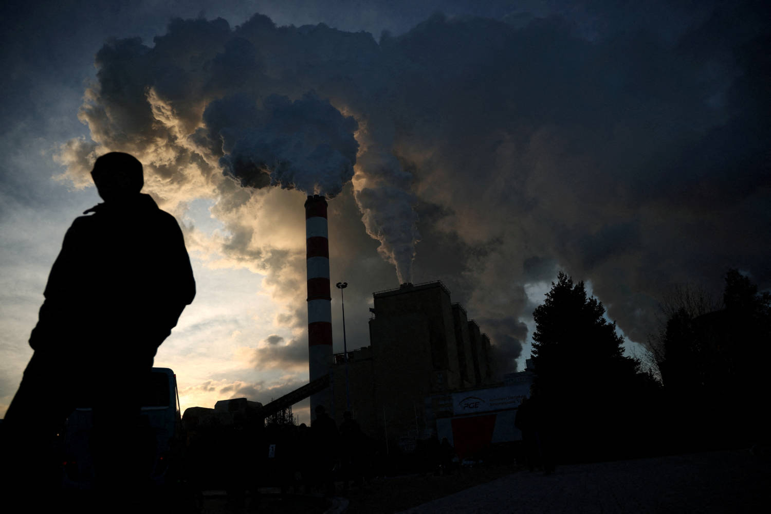File Photo: A Man Walks As Smoke And Steam Billow From Belchatow Power Station, Europe's Largest Coal Fired Power Plant Powered By Lignite, Operated By Polish Utility Pge, In Rogowiec