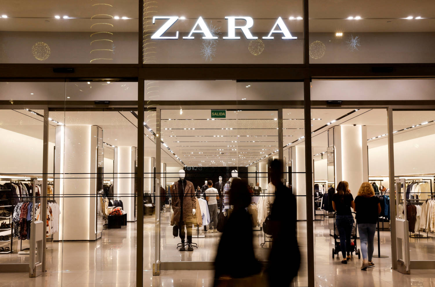 File Photo: Shoppers Walk Past A Zara Clothes Store, Part Of Spanish Group Inditex