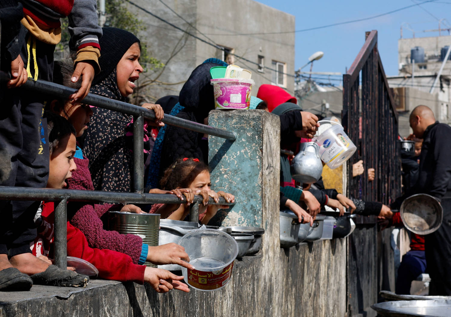 Palestinian Children Wait To Receive Food Cooked By A Charity Kitchen, In Rafah