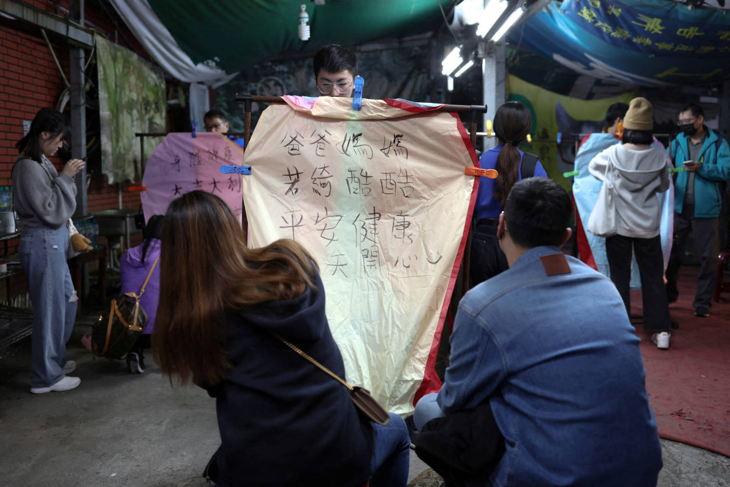 File Photo: People Write Wishes On Sky Lanterns Before Relasing Them Ahead Of The Lantern Festival In New Taipei City