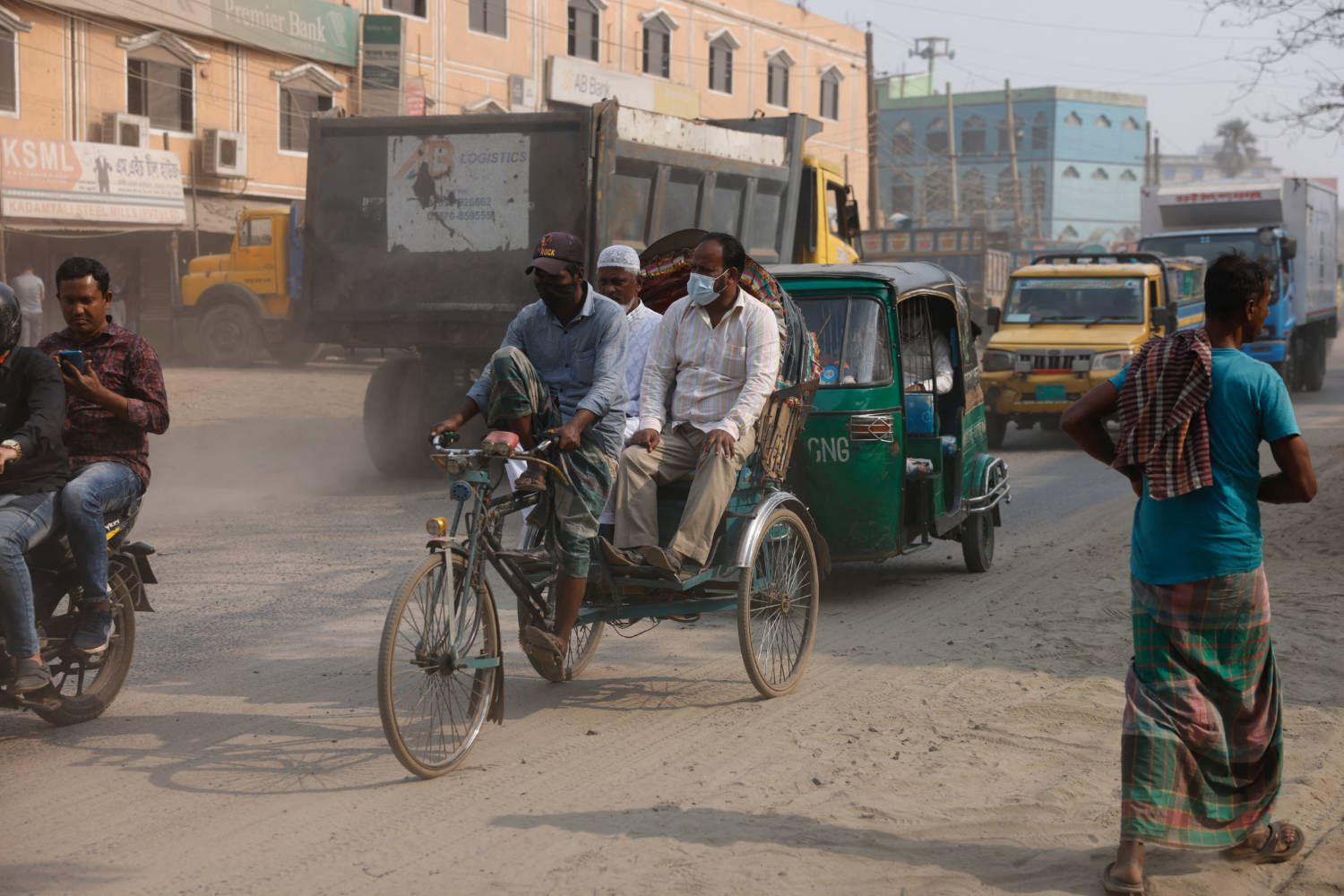 People Wear Masks As They Move Through The Dusty Road As Air Quality Decreases During Dry Season In Dhaka