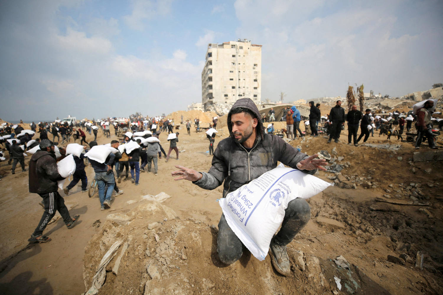 File Photo: Palestinians Carry Bags Of Flour They Grabbed From An Aid Truck Near An Israeli Checkpoint In Gaza City
