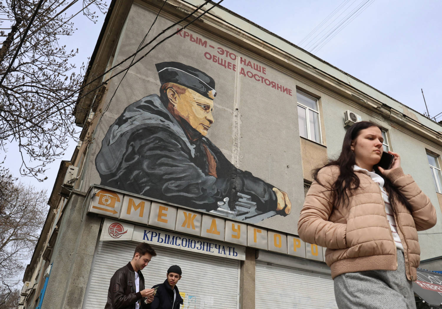People Walk Past A Mural Depicting Russian President Vladimir Putin In Simferopol