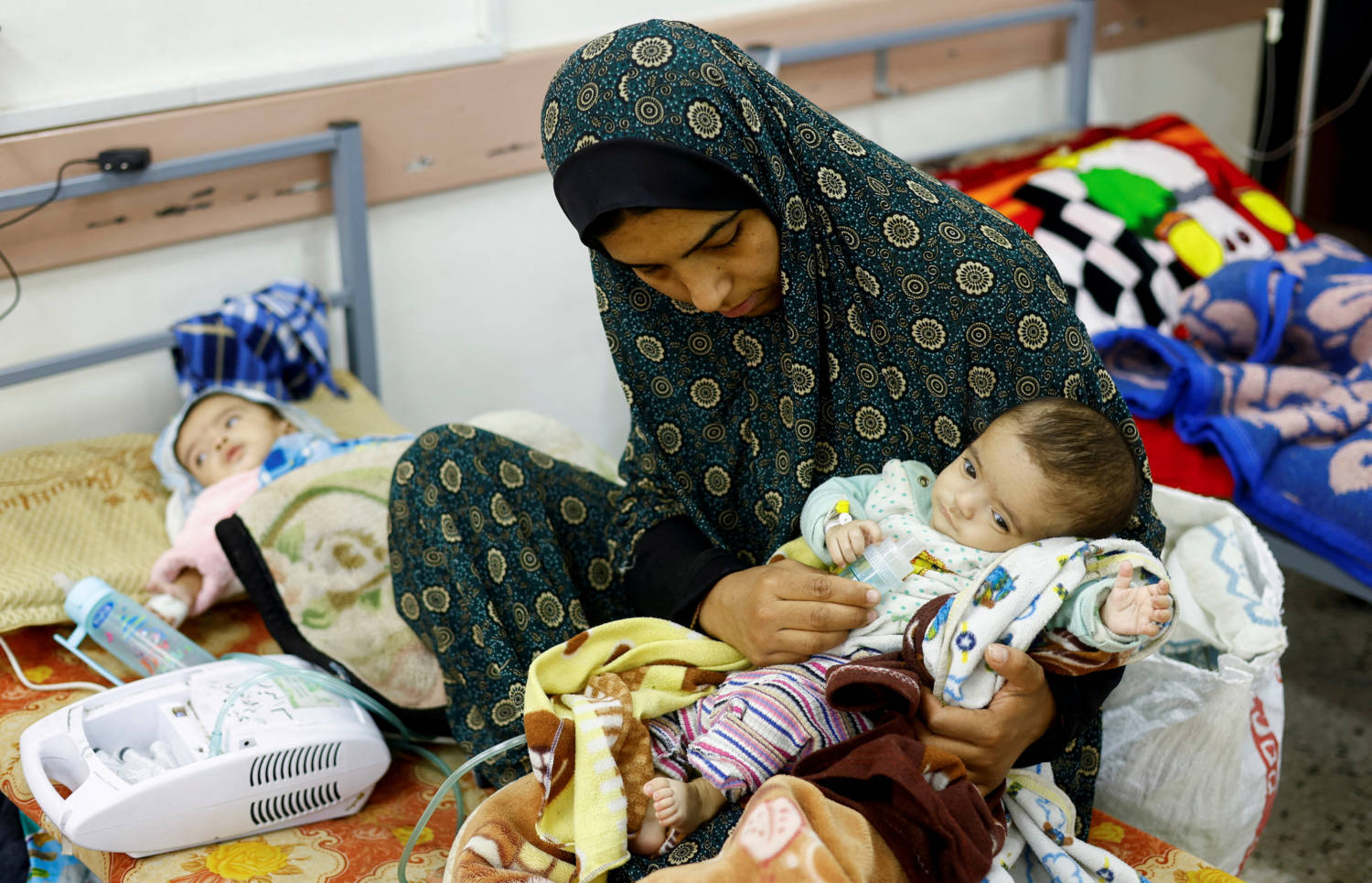 Palestinian Woman Wafaa Tabasi Holds Her Twin Malnourished Daughter Sameera, At Al Awda Health Centre In Rafah In The Southern Gaza Strip