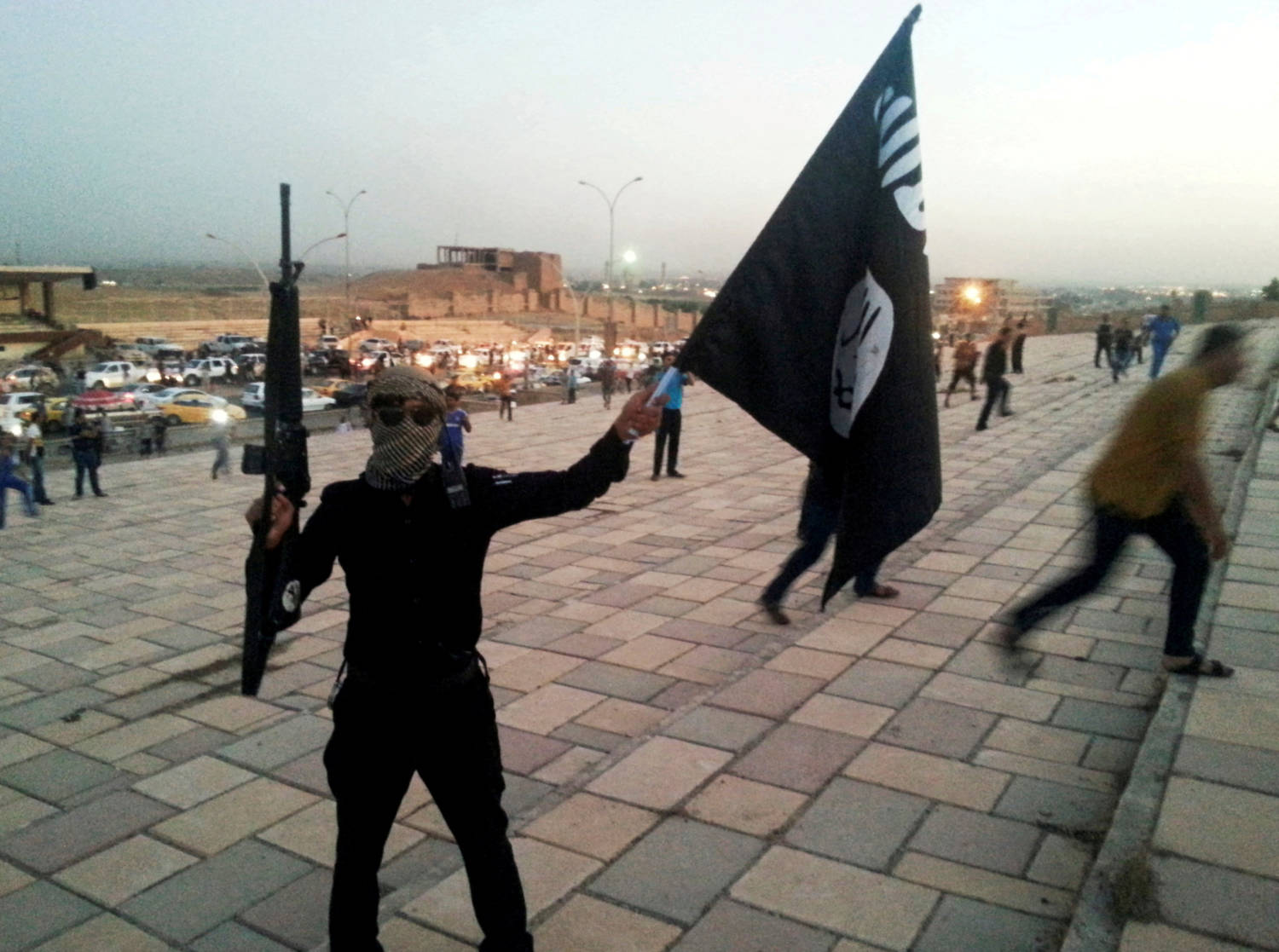 File Photo: A Fighter Of Isil Holds A Flag And A Weapon On A Street In Mosul