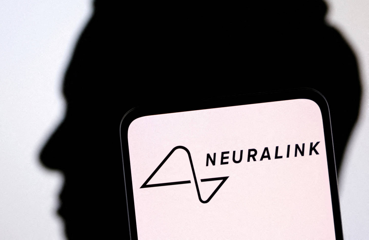 File Photo: Illustration Shows Neuralink Logo And Elon Musk Silhouette
