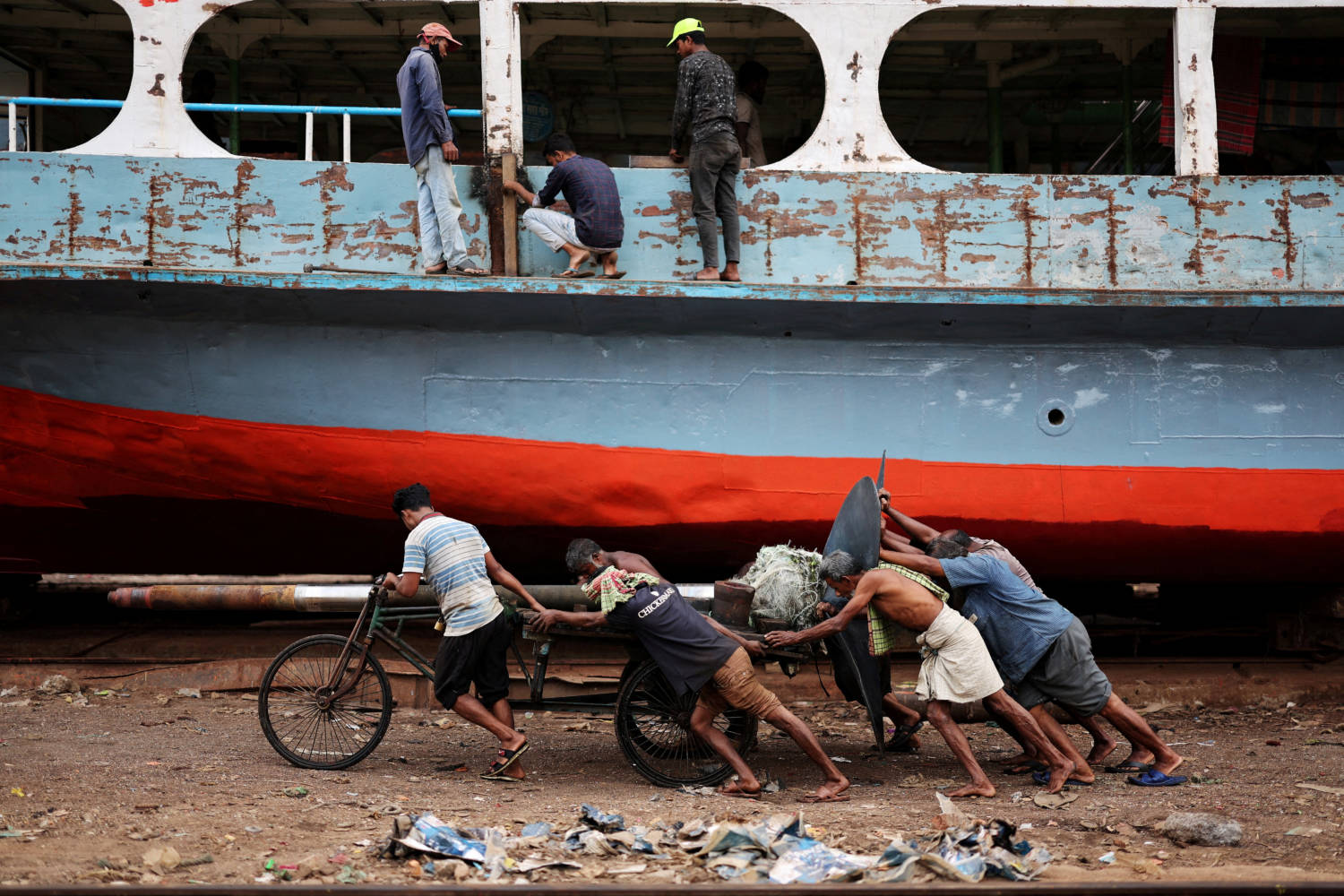 Bangladeshi Labourers Pull A Cart Carrying A Ferry Propeller In A Dockyard In Dhaka