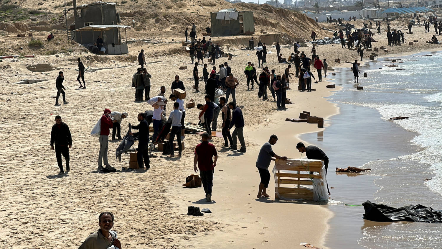 File Photo: Palestinians Gather On A Beach As They Collect Aid Airdropped By An Airplane, Amid The Ongoing Conflict Between Israel And Hamas, In The Northern Gaza Strip