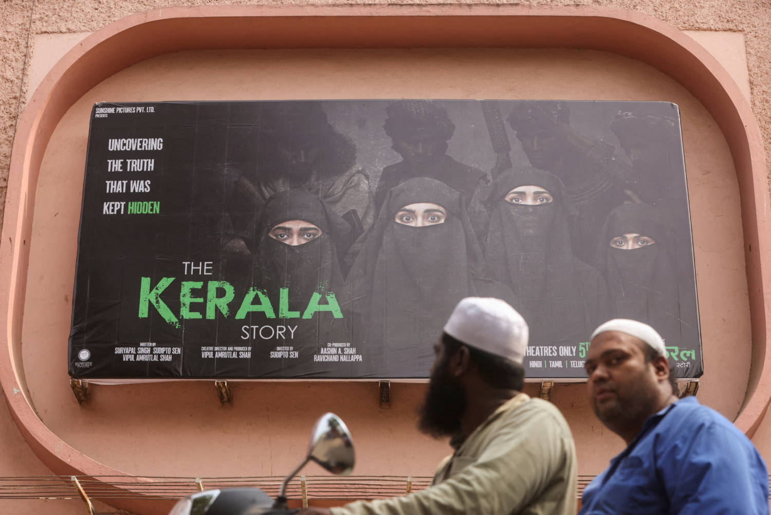 File Photo: People Ride Past A Poster Of A Hindi Movie Titled 