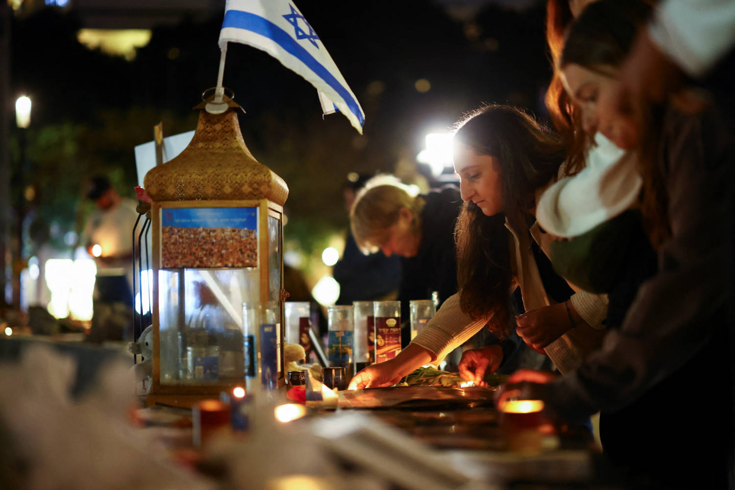 A Woman Lights A Candle Next To Memorabilia And Pictures Of The Hostages Kidnapped In The Deadly October 7 Attack On Israel By The Palestinian Islamist Group Hamas From Gaza, At Dizengoff Square In Tel Aviv