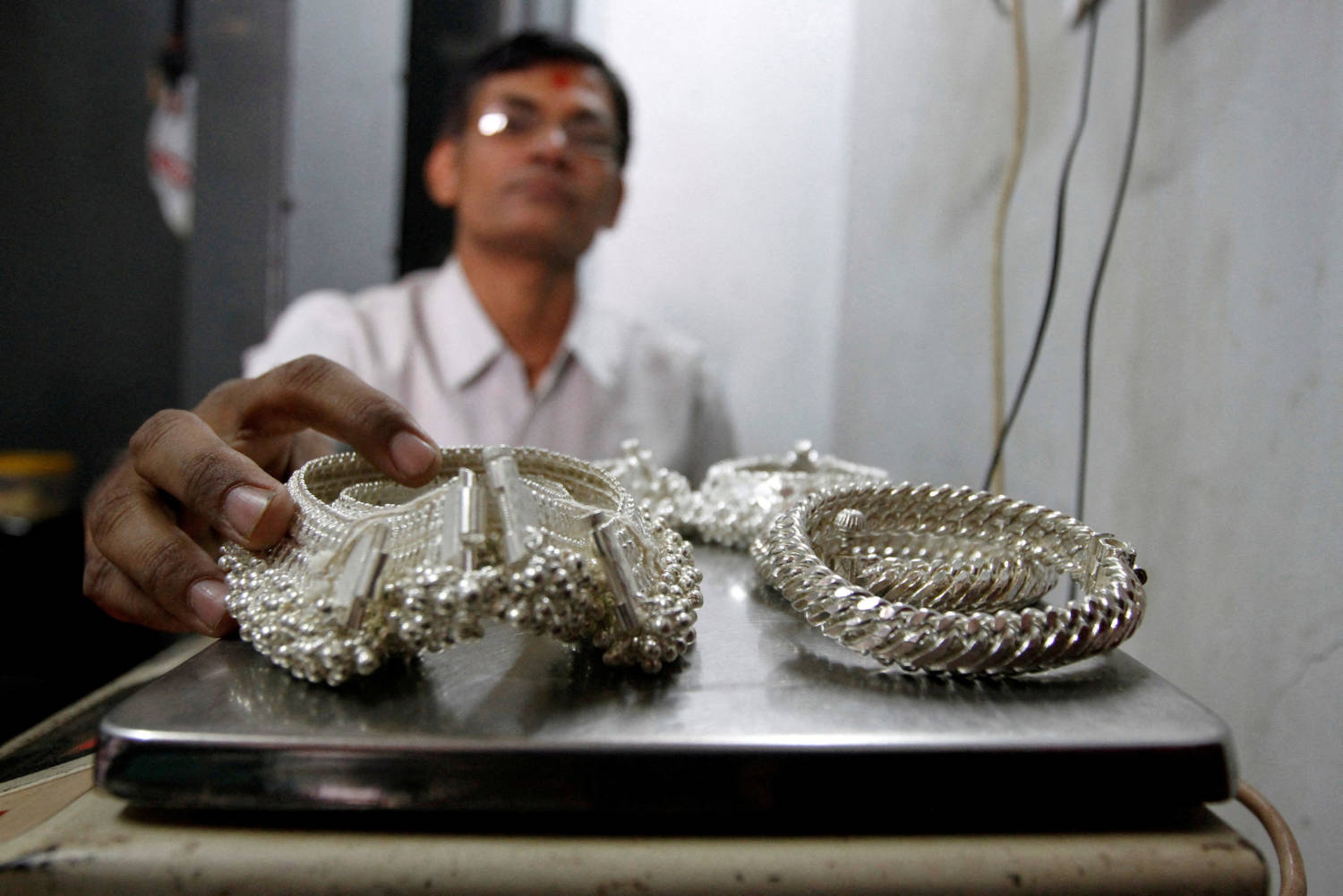File Photo: A Silver Trader Weighs His Silver Ornaments Inside His Shop In The Western Indian City Of Ahmedabad