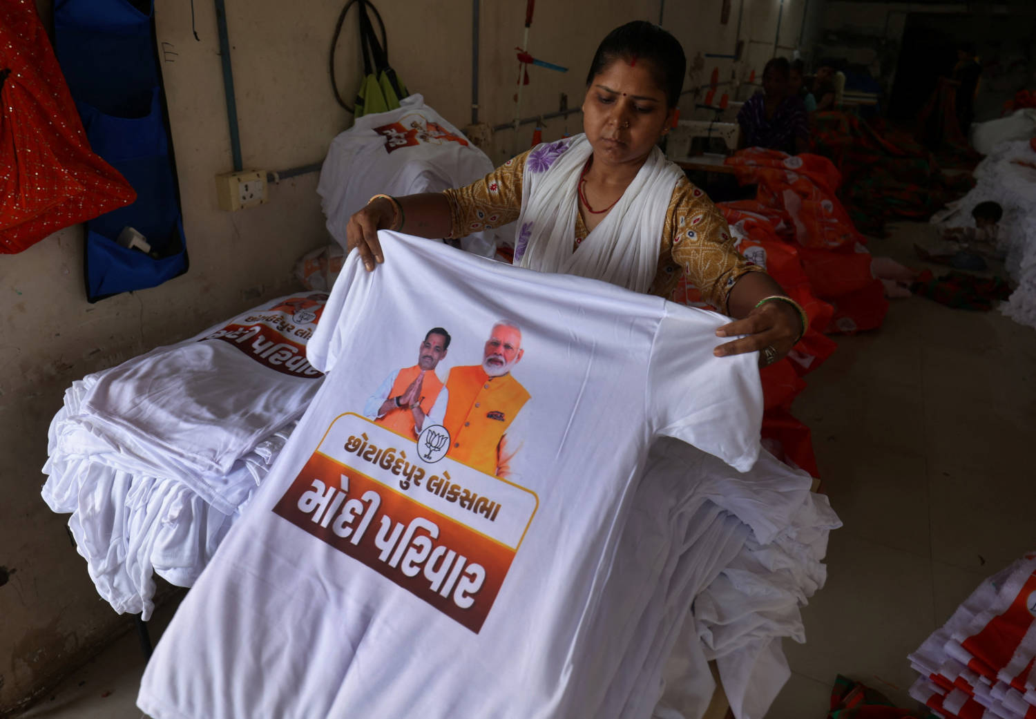 A Worker Arranges T Shirts Carrying A Picture Of Indian Prime Minister Narendra Modi And A Bharatiya Janata Party (bjp) Candidate, Inside An Election Campaigning Material Manufacturing Unit Ahead Of The General Elections On The Outskirts Of Ahmedabad
