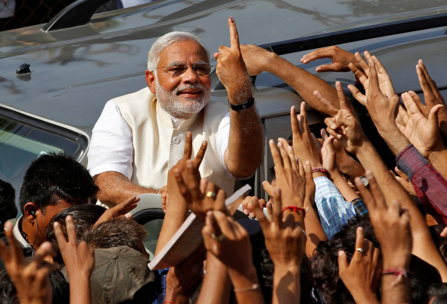 File Photo: Modi Shows His Ink Marked Finger To His Supporters After Casting His Vote In Ahmedabad