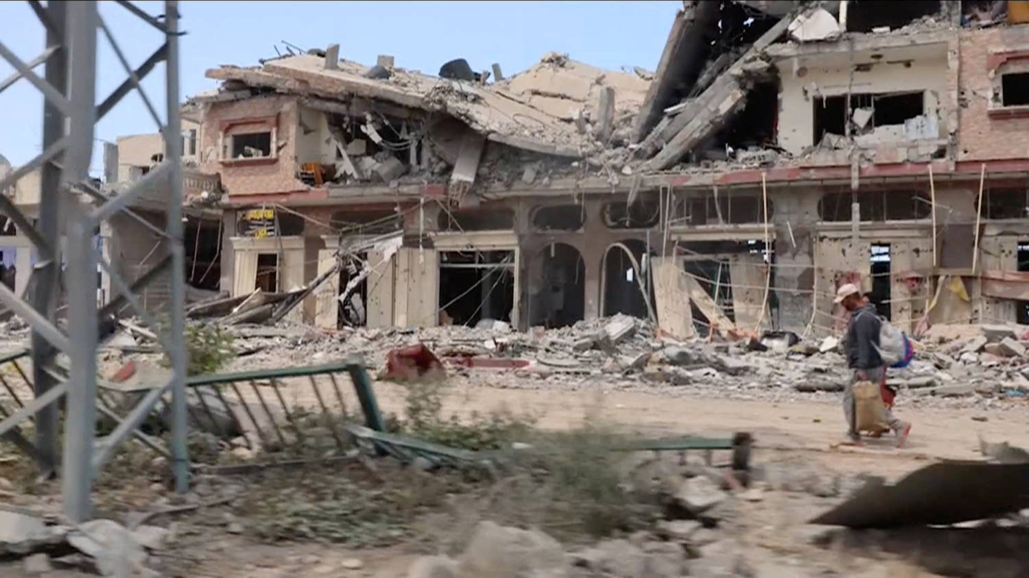People Walk Past Destroyed Buildings In Khan Younis