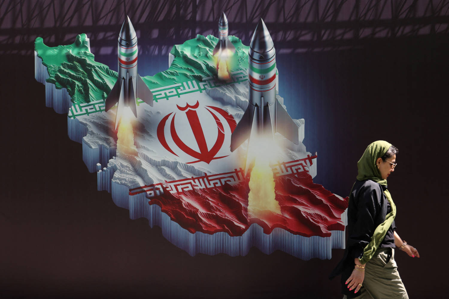 An Iranian Woman Walks Past An Anti Israel Banner With A Picture Of Iranian Missiles On A Street In Tehran