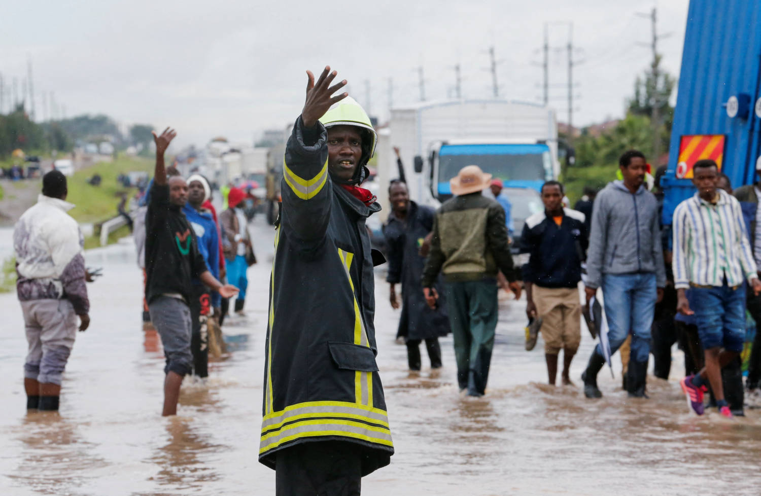 A Firefighter Directs Traffic To Clear The Athi River Namanga Highway That Was Affected After A Seasonal River Burst Its Banks Following Heavy Rainfall In Kitengela Municipality Of Kajiado County