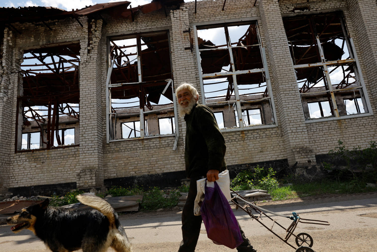 A Local Resident Walks Past A Destroyed Building In Popasna